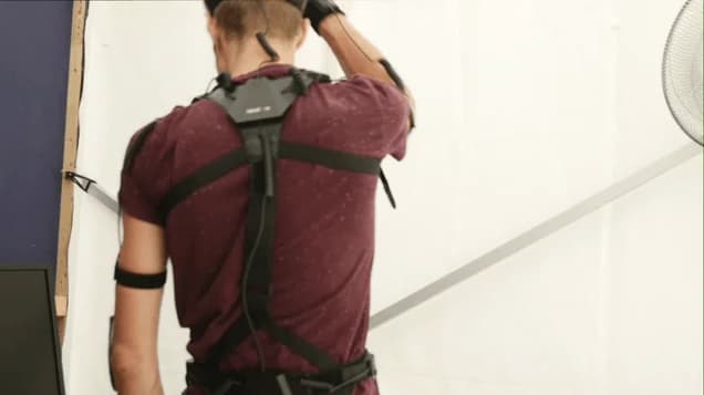 Platzhalterbild: Motion‑Capture‑Schauspieler mit Tracking‑Markern neben Live‑Kamera und Monitor, der das Composited Bild zeigt.