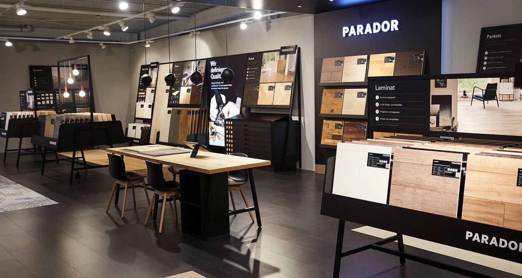 Foto des interaktiven Tisches im Parador Studio Concept mit aufgelegten Mustertafeln und iPad‑Interface