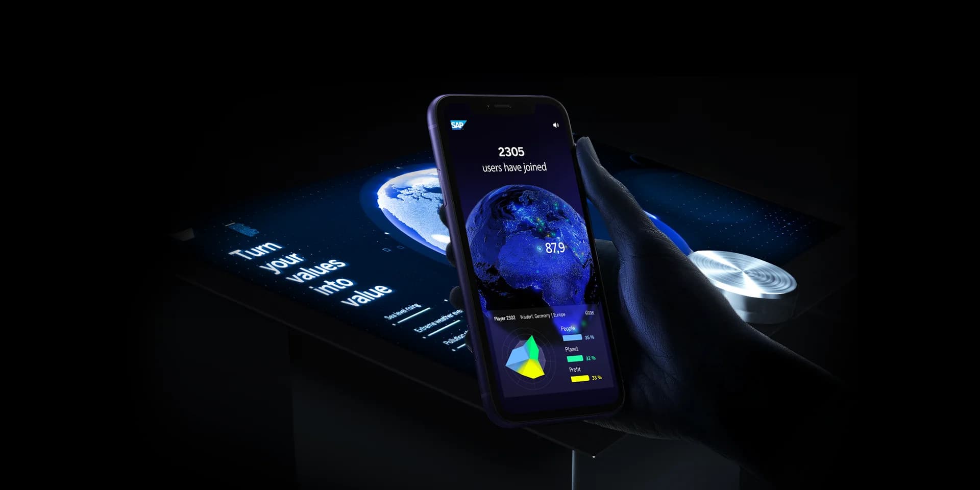 Platzhalter: Übersichtsbild des hybriden Events mit Messe-Terminals im Vordergrund und vernetzten Web-Teilnehmern auf Bildschirmen im Hintergrund.