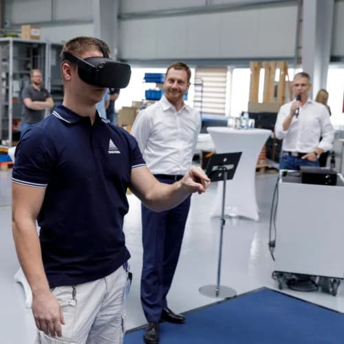 VR‑Teilnehmer mit Oculus Quest und sichtbaren virtuellen Händen beim Bedienen eines Isolators