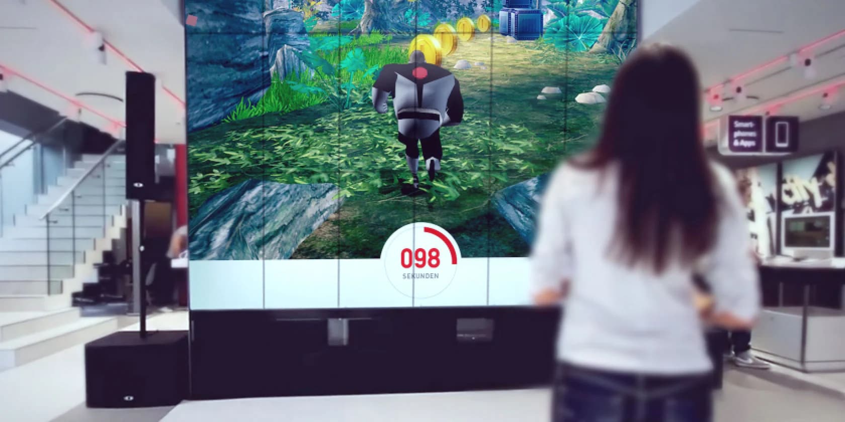 Vollformatige Videowand (3,5 m × 7 m) aus 36 Bildschirmen mit Publikum davor als atmosphärischer Platzhalter