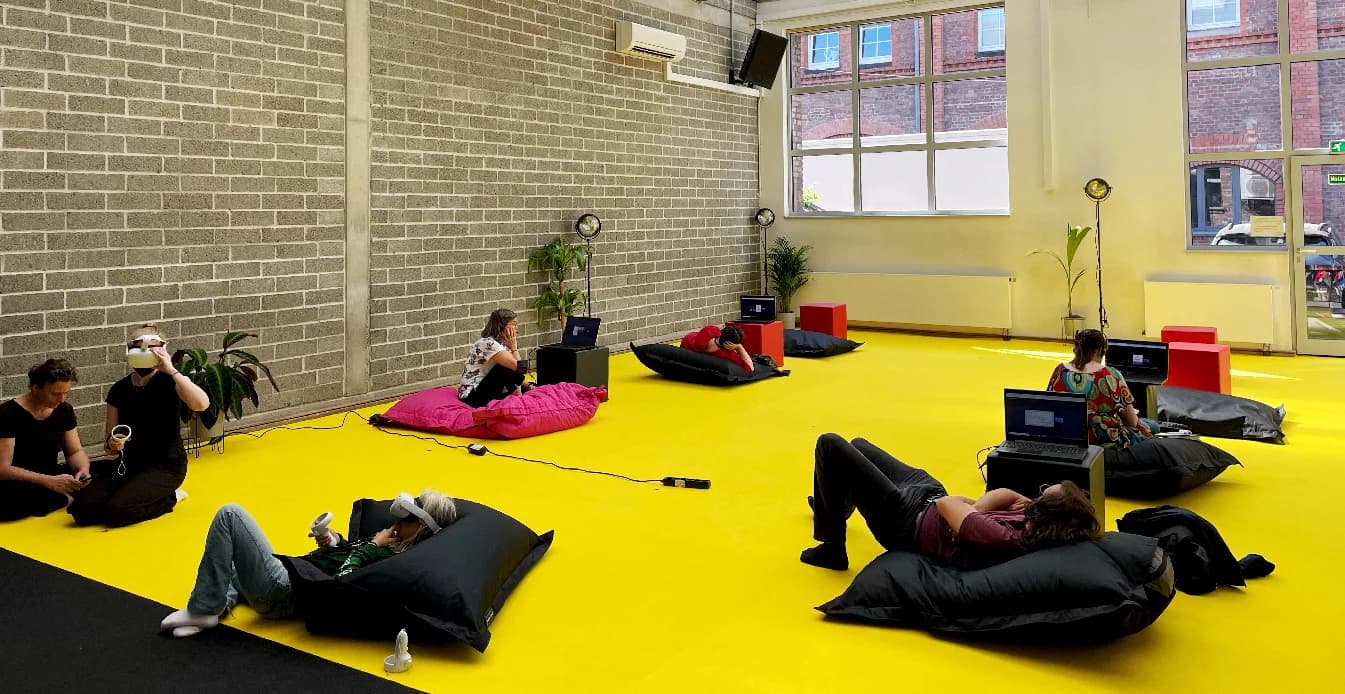 Visualisierung des virtuellen Ausstellungsraums mit Videowalls und Avataren (Platzhalter)